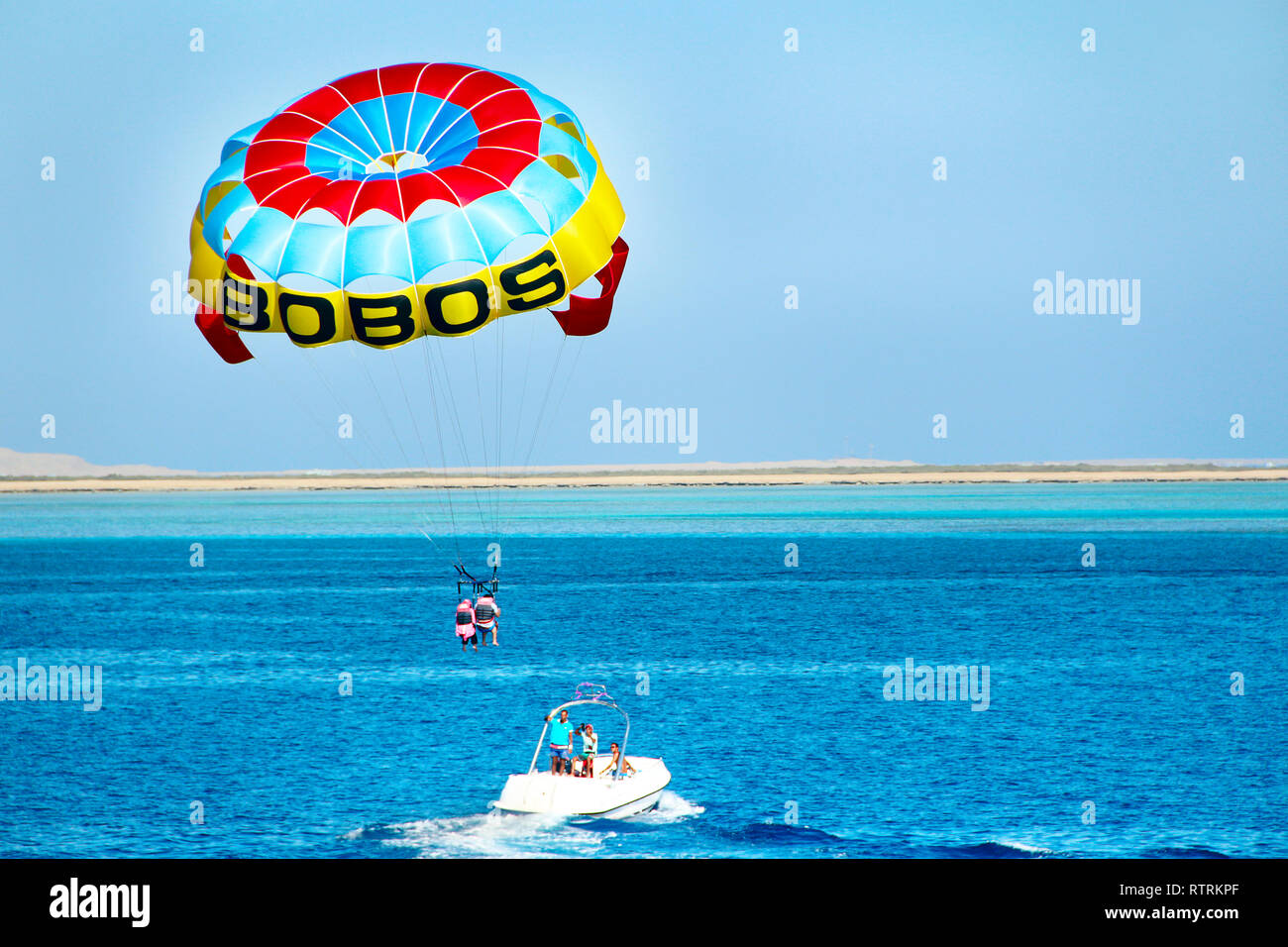 Man is fond of parasailing over Red Sea. Tropical resort in Egypt. People rest on Egyptian resort. Travel concept. Flying on parachute behind boat on  Stock Photo