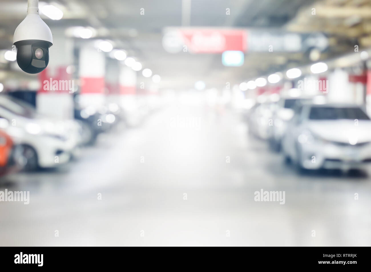 cctv security camera on blur underground cars parking garage with light on exit way use as background Stock Photo