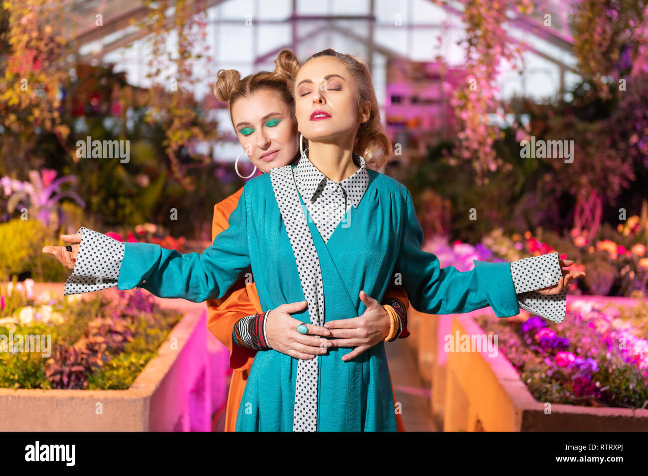 Nice young woman standing behind her friend Stock Photo