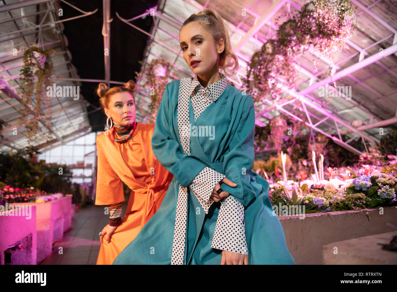 Beautiful blonde woman being in the greenhouse Stock Photo - Alamy