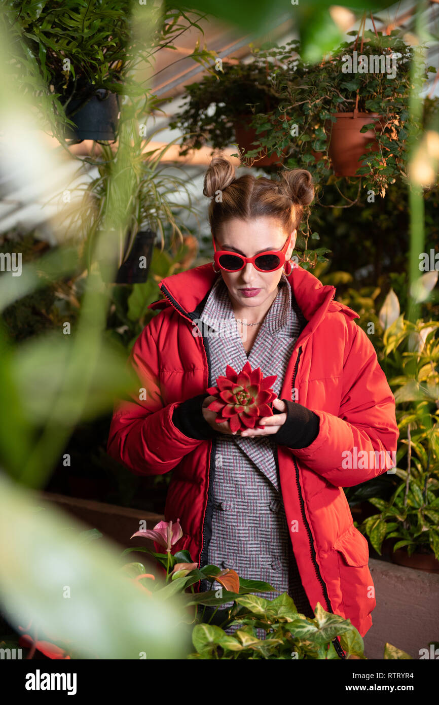 Nice serious woman looking at the rare flower Stock Photo