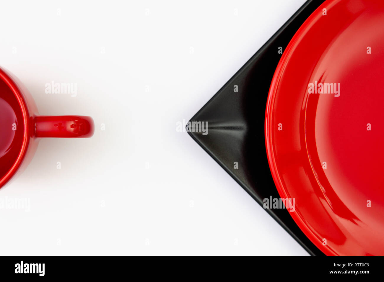 Different  red and black plates and red cup on the white table.Top view. Flat Lay Image. Stock Photo