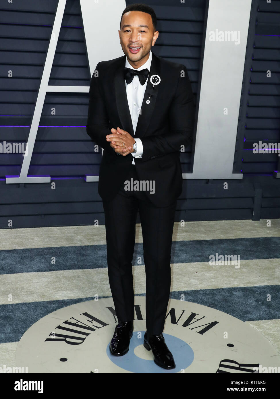 BEVERLY HILLS, LOS ANGELES, CA, USA - FEBRUARY 24: Singer John Legend  wearing a Gucci tux, Christian Louboutin shoes, and a Dennis Tsuii pin  arrives at the 2019 Vanity Fair Oscar Party