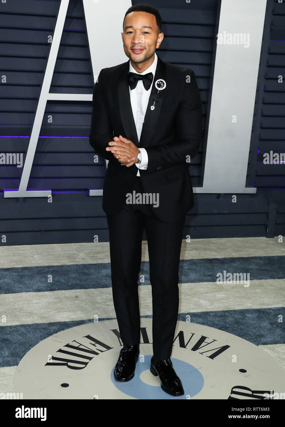 BEVERLY HILLS, LOS ANGELES, CA, USA - FEBRUARY 24: Singer John Legend  wearing a Gucci tux, Christian Louboutin shoes, and a Dennis Tsuii pin  arrives at the 2019 Vanity Fair Oscar Party