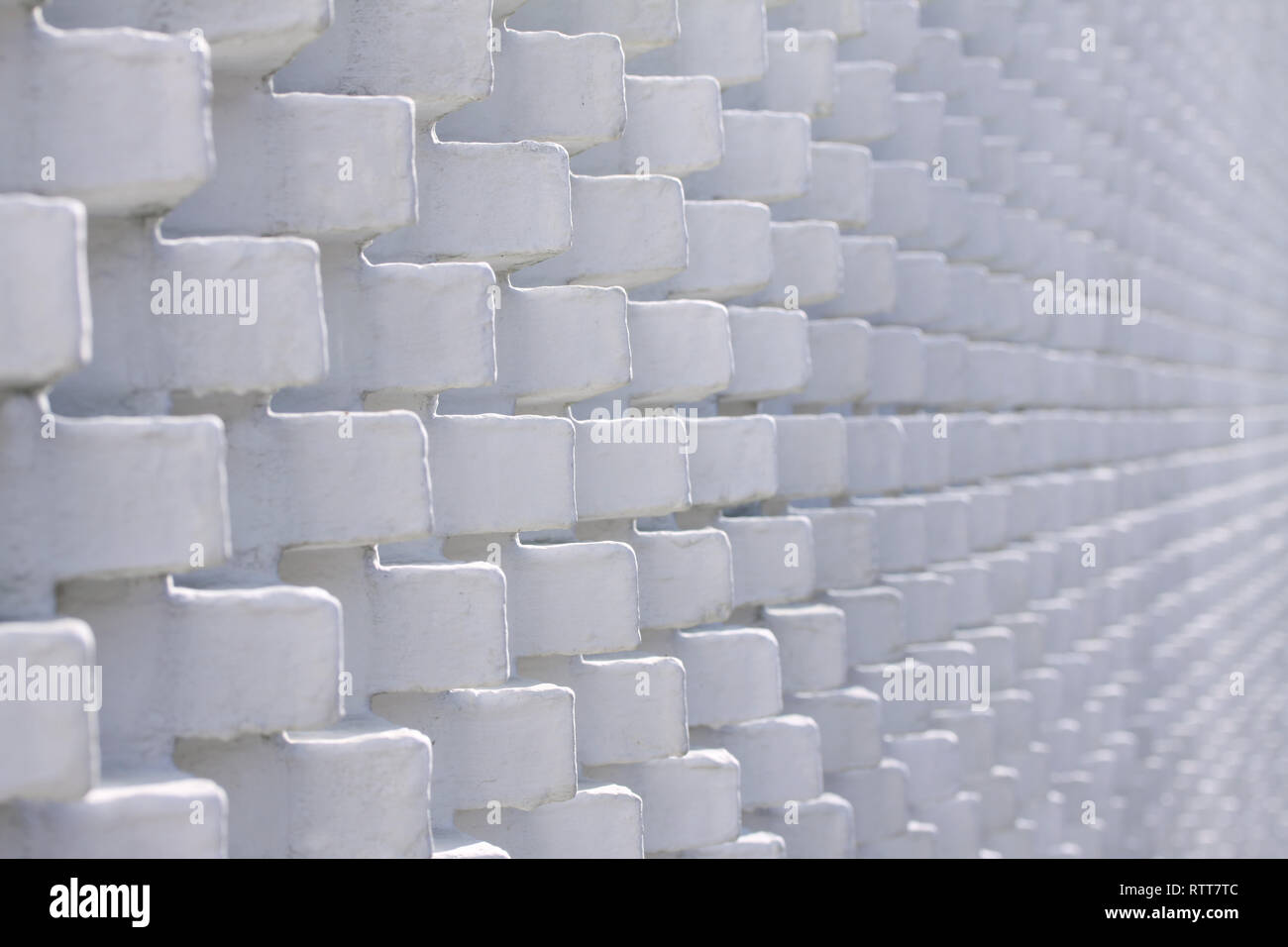 White brick wall in unusual pattern with bricks sticking out - selective focus Stock Photo