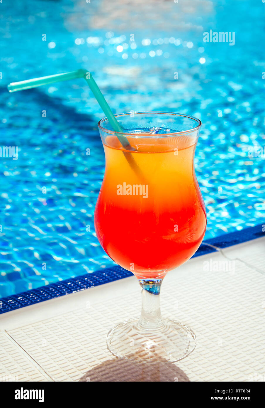 A layered cocktail on swimming pool background Stock Photo - Alamy