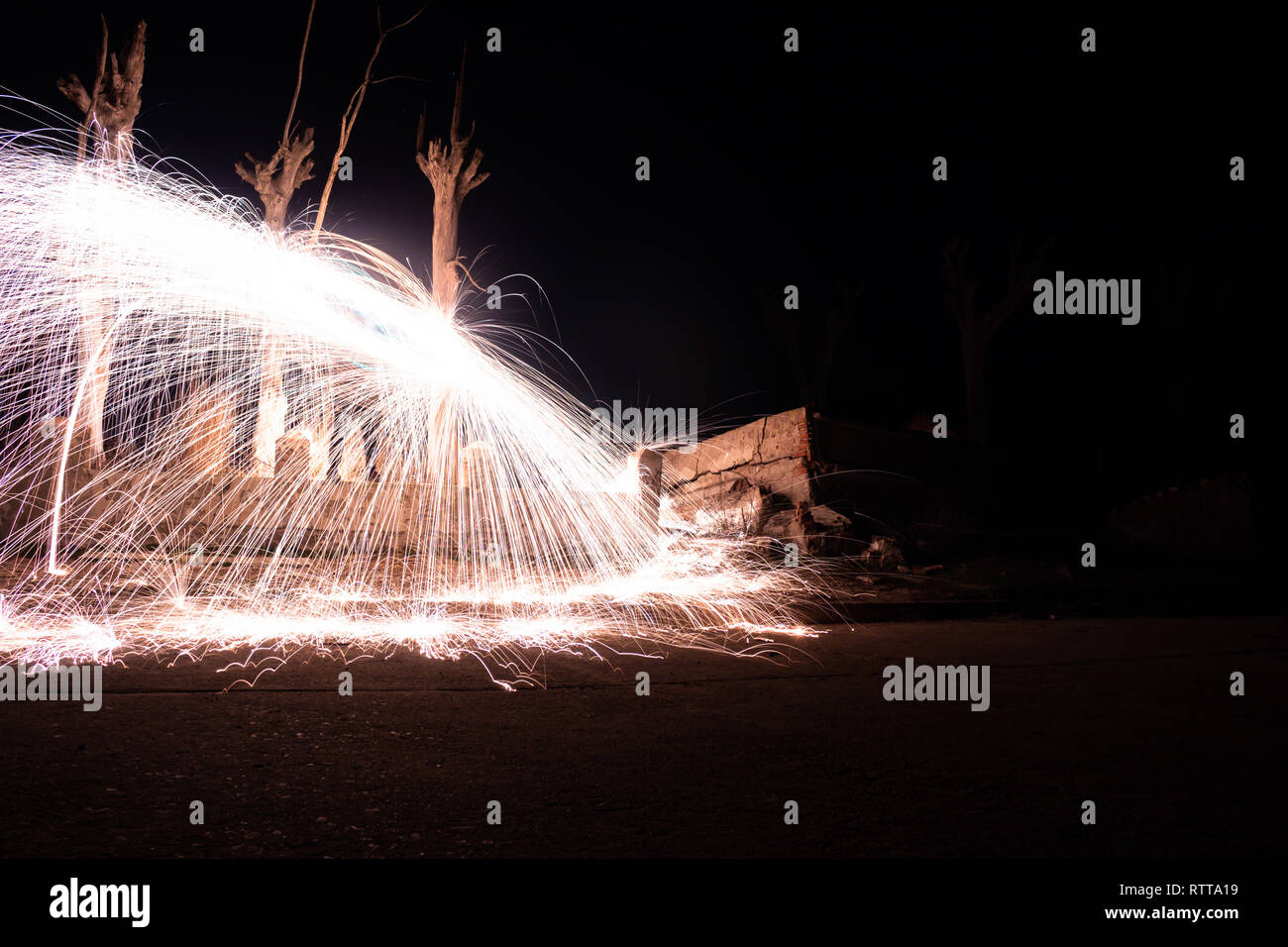 Effect of sparks of incandescent steel. Long exposure photo. light painting technique Fire wall in the abandoned city of Epecuen. Stock Photo