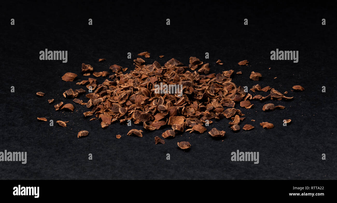 Grated chocolate. Heap of ground chocolate isolated on black background, closeup Stock Photo