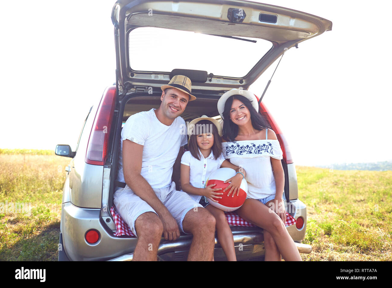 A happy family has a car on a summer trip. Stock Photo
