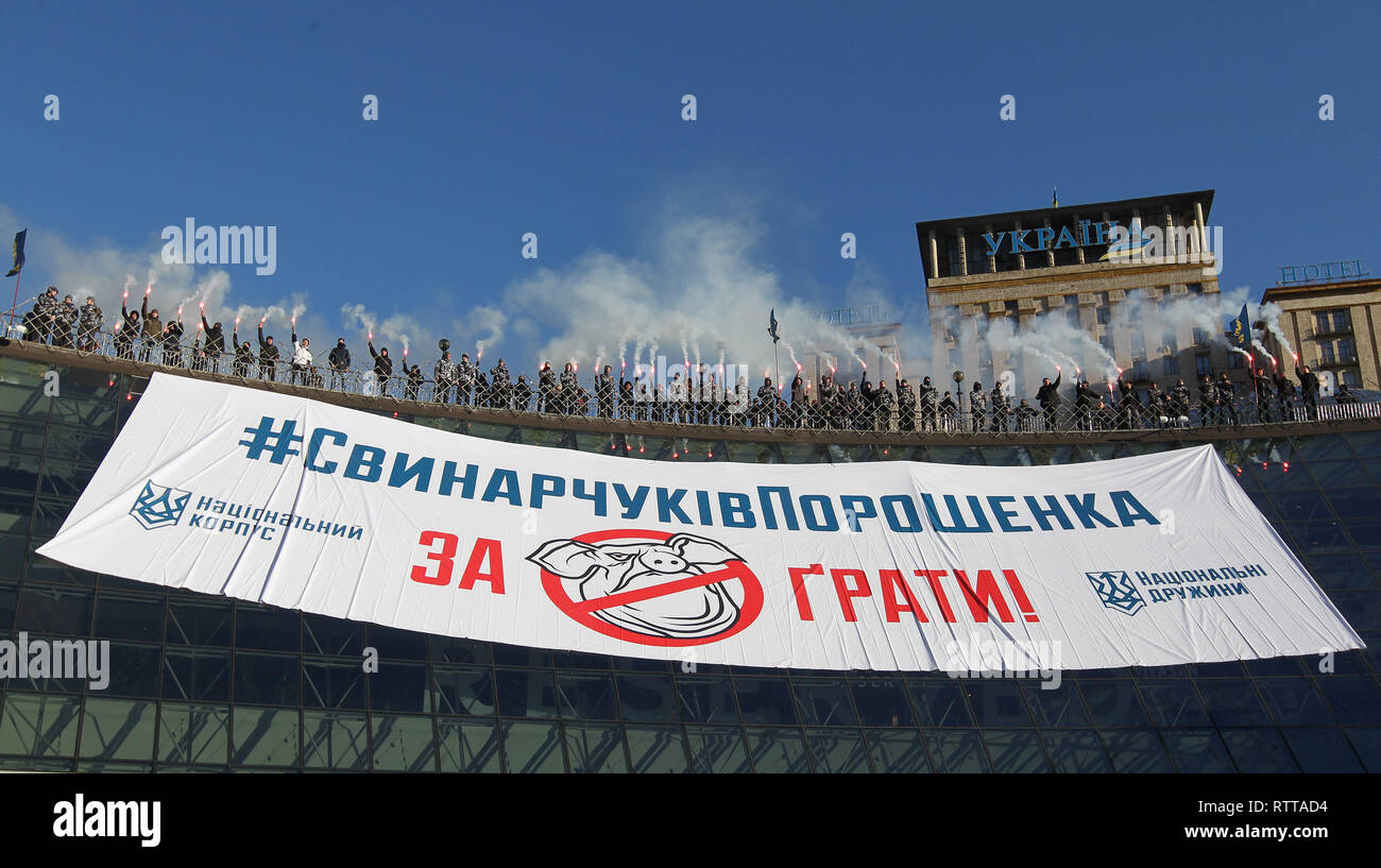 Activists and supporters of 'National Corps' Ukrainian nationalist parties are seen burning flares while holding a banner with the demand to imprison those involved in embezzling budget funds in the defence sector during the protest at the Independence square in Kiev. On February 25 the journalists released the investigative report claiming that Ihor Gladkovsky, the son of First Deputy Secretary of the NSDC Oleh Hladkovsky, is involved in large-scale schemes of embezzling budget funds in the defence sector. Ukrainian President of Ukraine Petro Poroshenko is demanding that law enforcement agenc Stock Photo