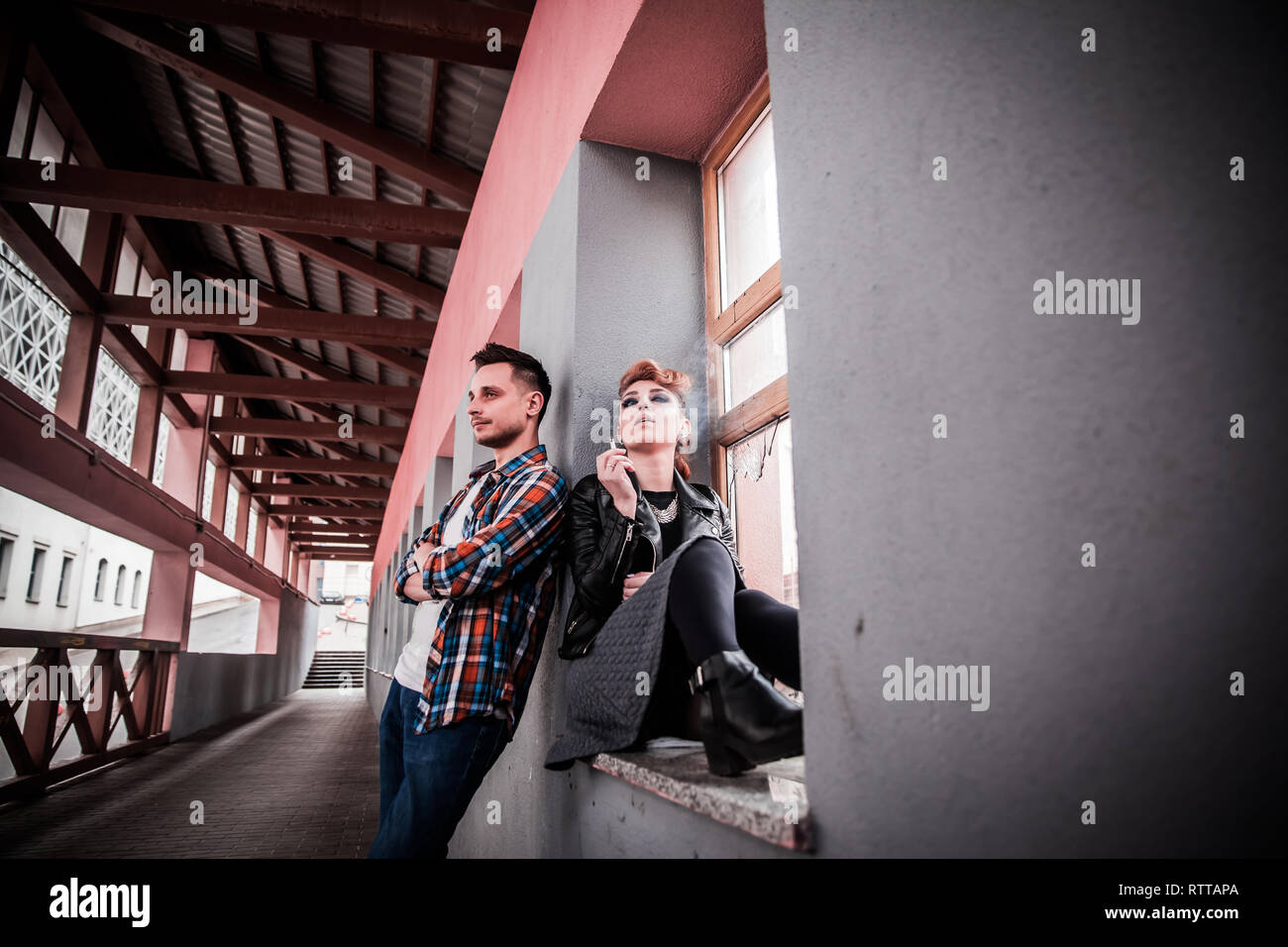 young woman and her boyfriend quarrel in the entrance of a house Stock Photo