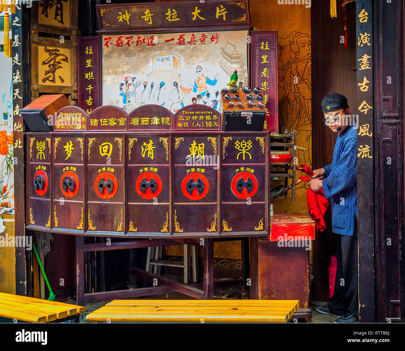 Layang Pian or Xiyang Jian is a peep show featuring a set of theatrical pictures which the showman pulls into the viewing positions with a string. Stock Photo