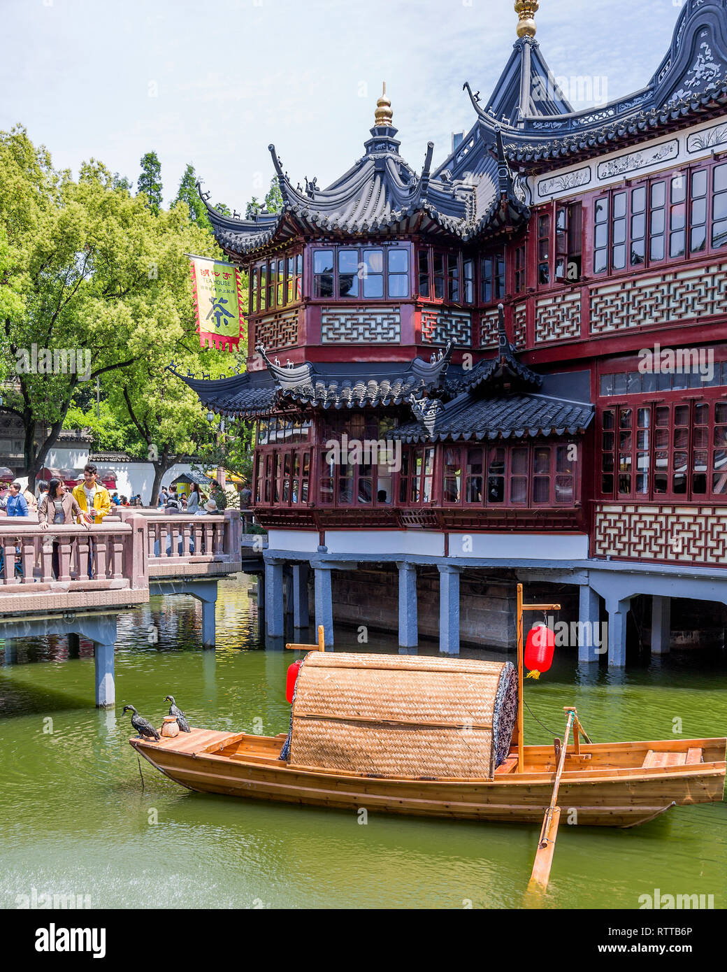 Huxinting Tea House aka Mid-lake Pavilion Teahouse stands on stilts in the middle of a man made lake. A traditional Chinese fishing boat in the fore. Stock Photo