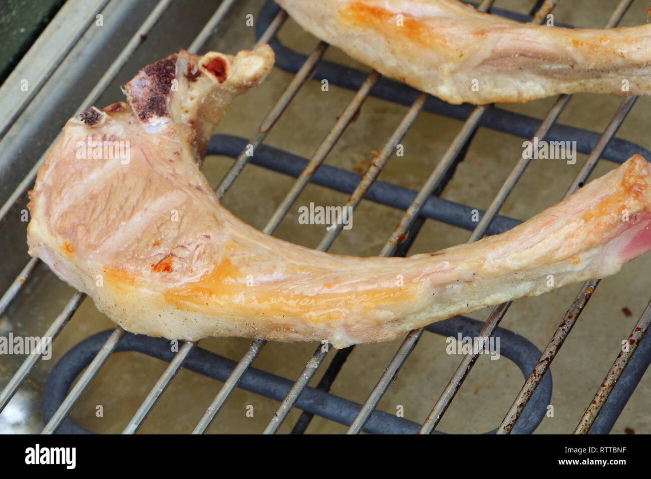 Lamb chops on the rack of an electric barbecue Stock Photo