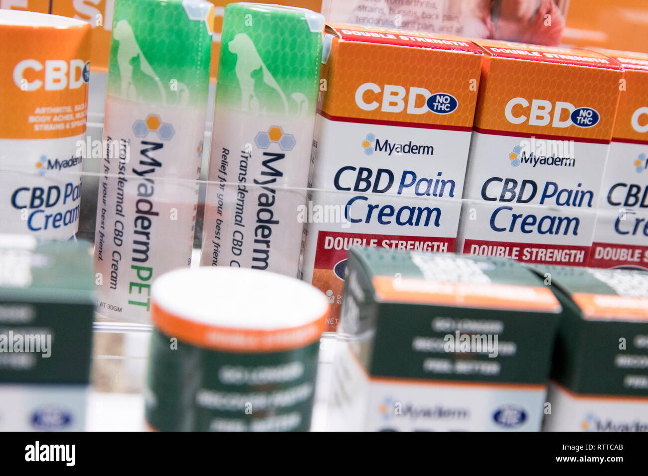 Bottles of Myaderm CBD (Cannabidiol) pain cream treatment products photographed in a pharmacy. Stock Photo