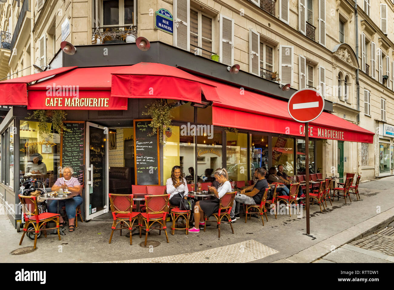 People sitting at tables outside Cafe Marguerite on Rue des Martyrs ,St Georges  in the 9th arrondissement of Paris, France Stock Photo