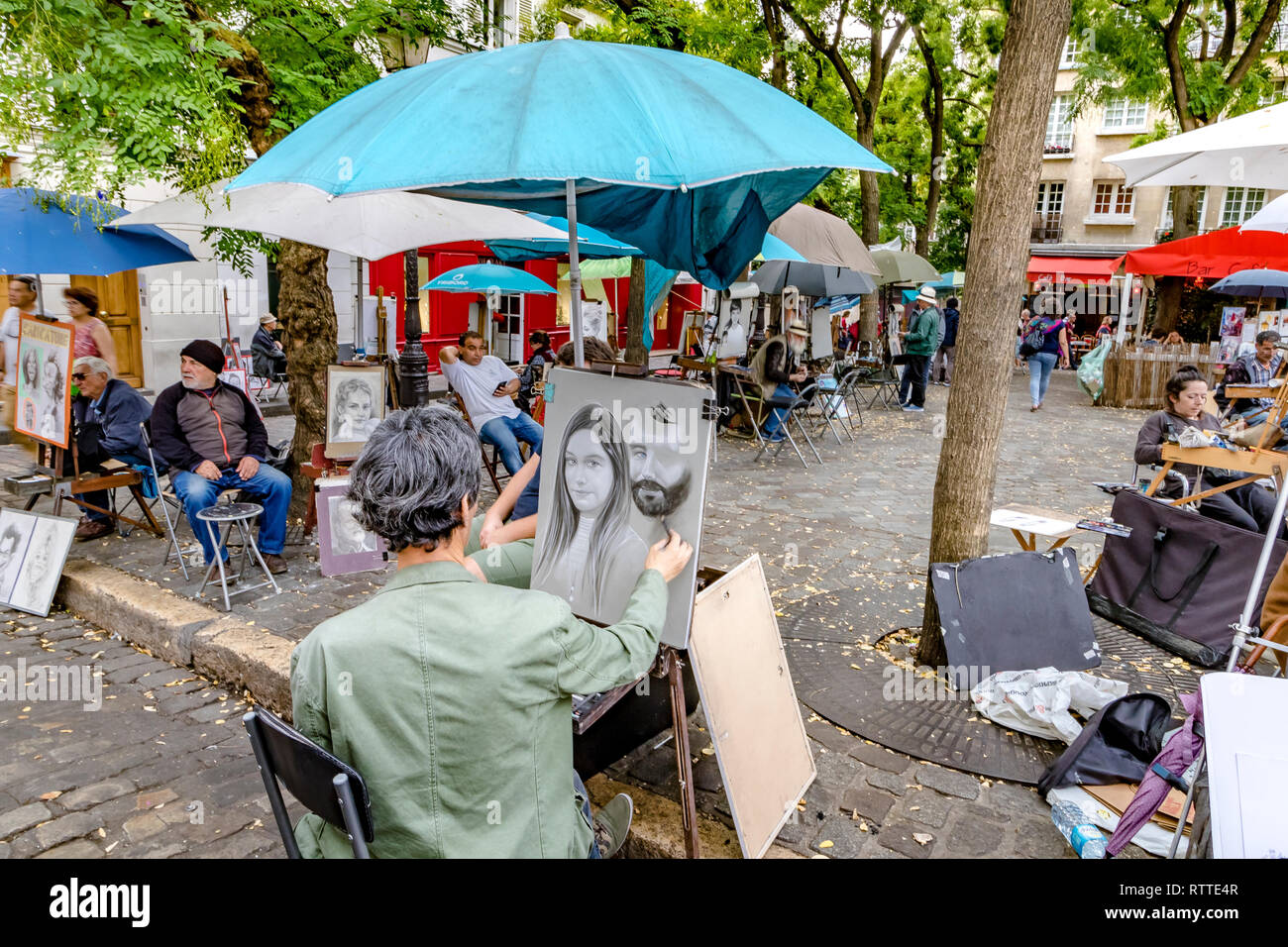 An artist at work sketching a portrait of woman in Place Du Tetre ,a popular Square in Montmartre, Paris, France Stock Photo
