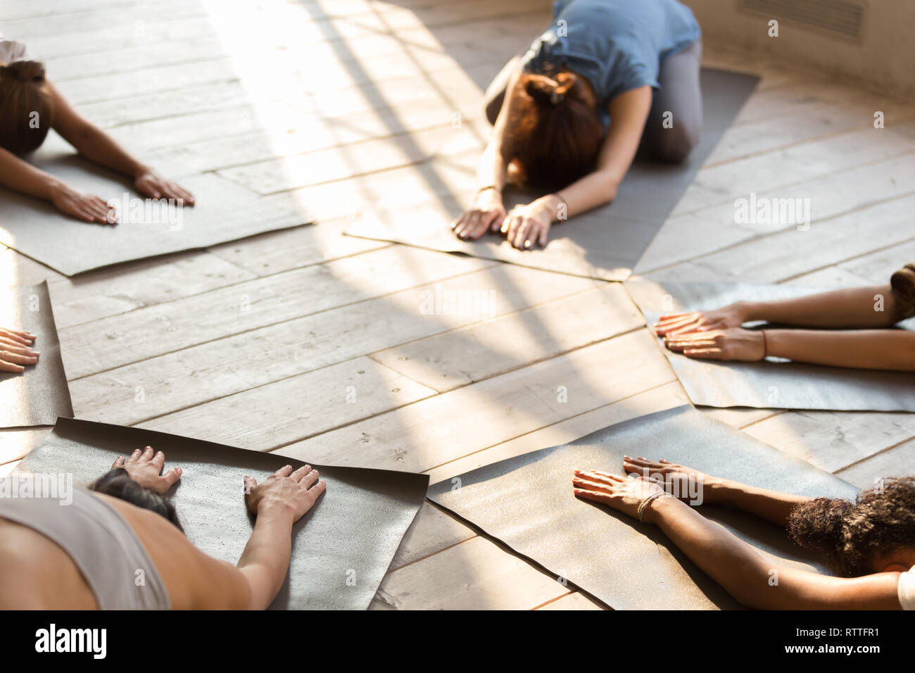 Group of young people practicing yoga lesson, doing Child exercise Stock Photo