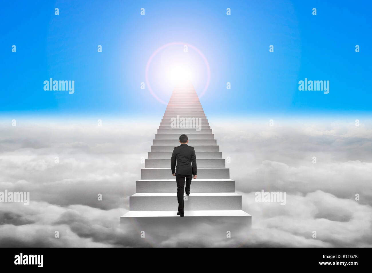 Businessman climbing the concrete stairs with blue sky sunlight ...