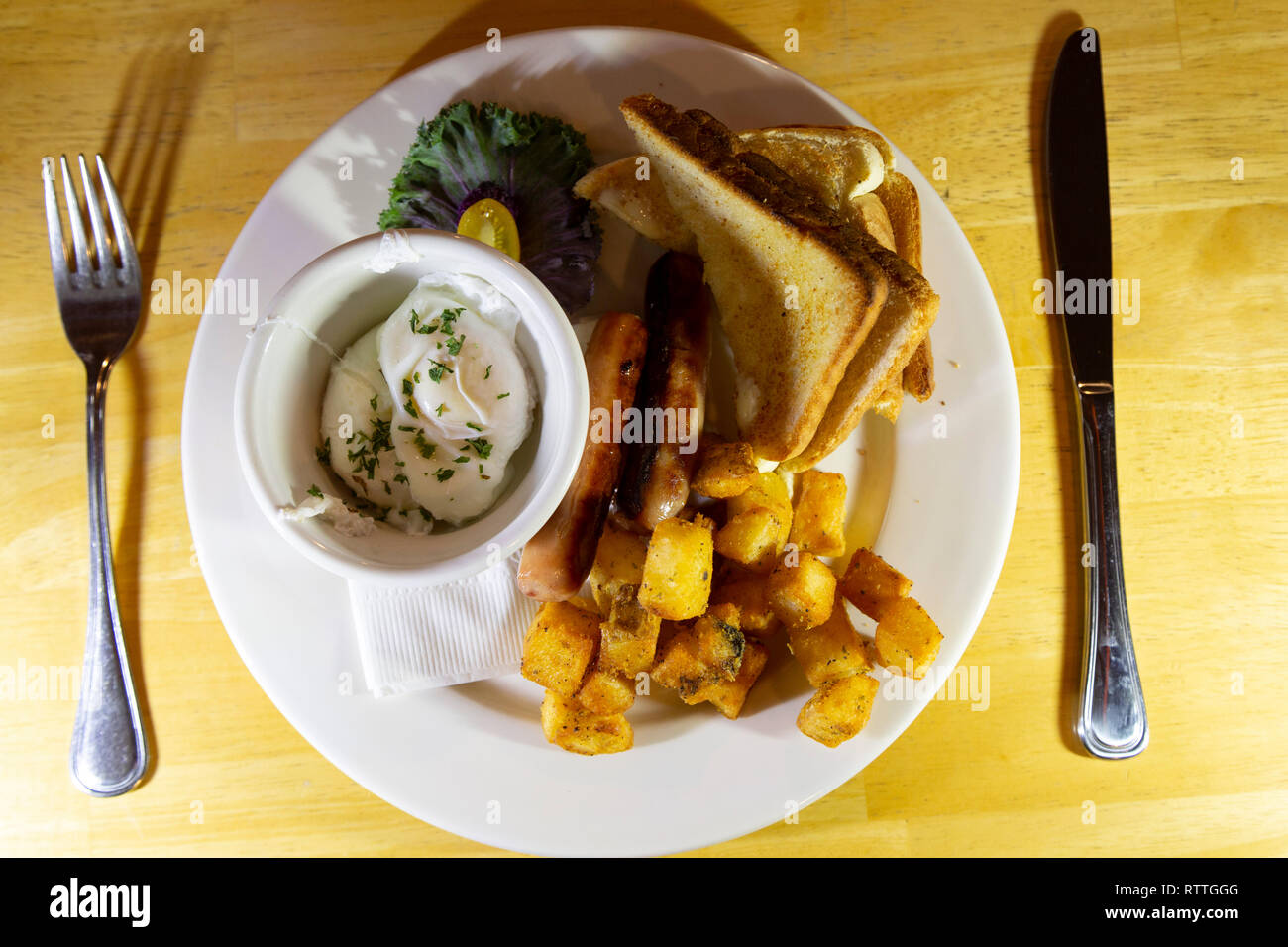 A Canadian breakfast served in Manitoba, Canada. It features sausages, a poached egg, toast and hash potatoes. Stock Photo