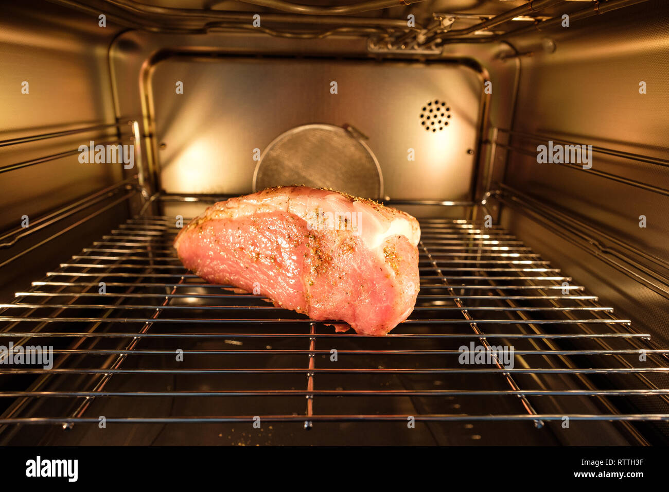 Raw pork crust roast in a backing oven of stainless steel Stock Photo