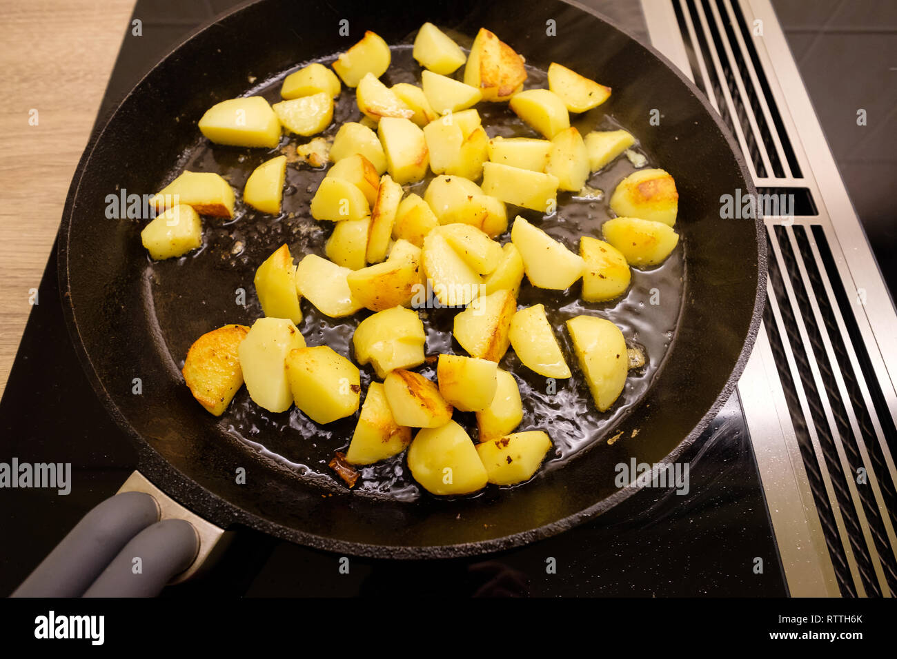 Fried potatoes in a pan with dripping on a stove Stock Photo Alamy