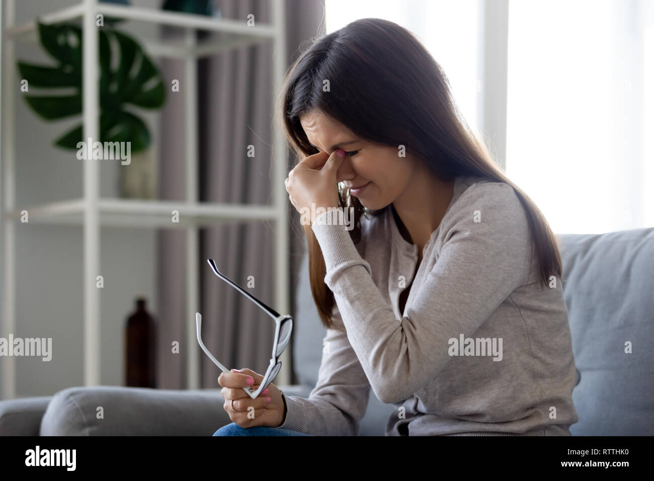 Upset woman taking off glasses, suffering from eye strain Stock Photo