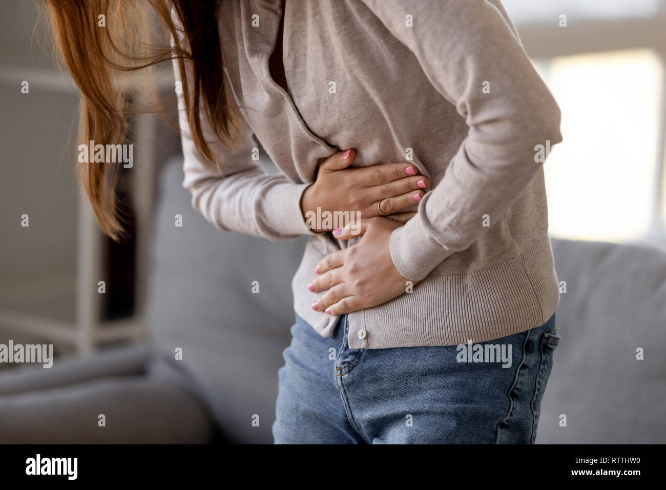Close up woman holding belly, feeling pain, health problem concept Stock Photo