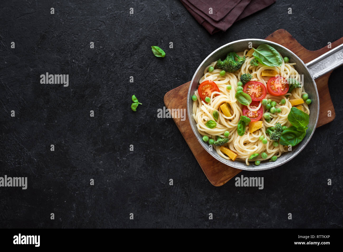 Pasta Primavera. Spaghetti pasta with vegetables and basil, top view