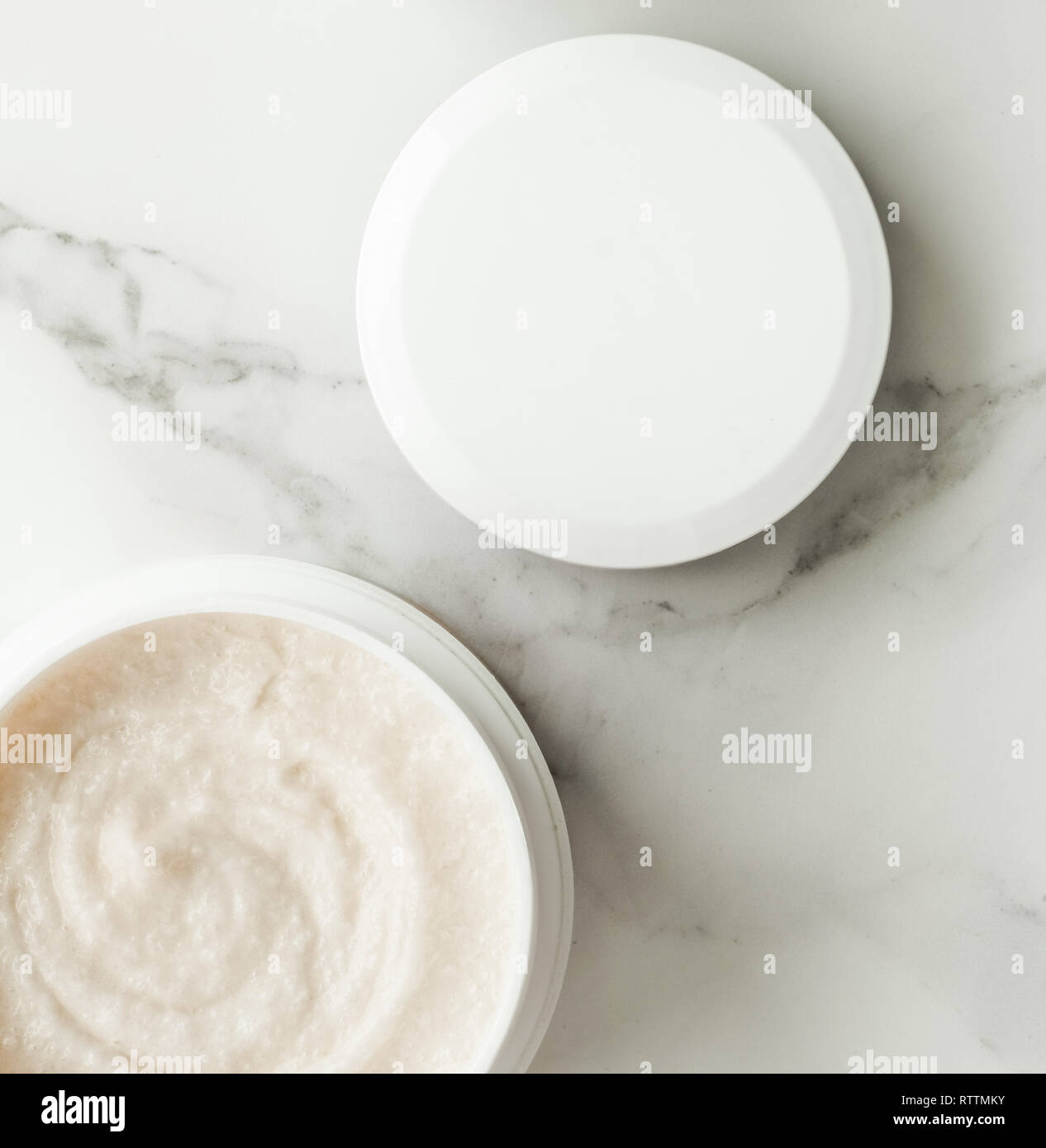 Scrub and exfoliating cream products on a marble, flatlay skincare