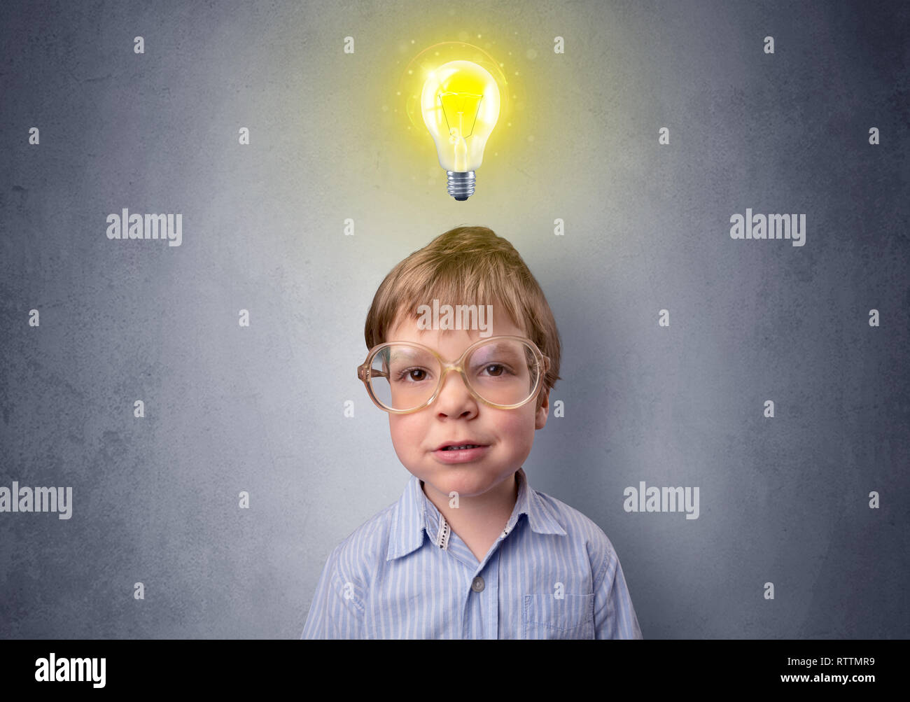 Adorable little kid mull over in front of a grey wall with idea symbol