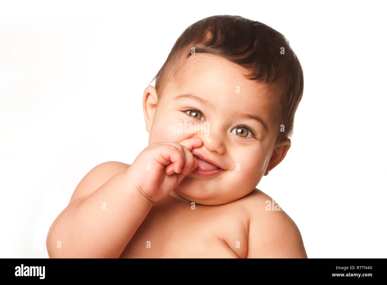 Cute happy innocent baby infant with big light green eyes picking nose, childhood concept, on white. Stock Photo