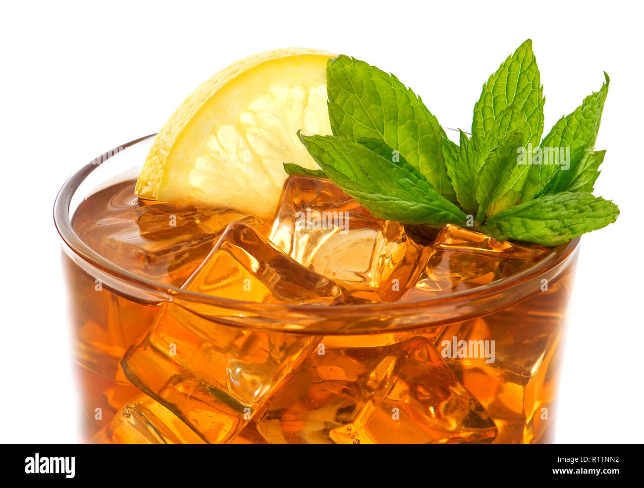 The glass of ice tea garnished with lemon and mint, isolated on white background. Stock Photo