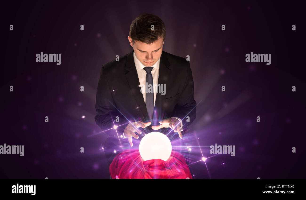 Young businessman sitting with crystal ball in action Stock Photo - Alamy