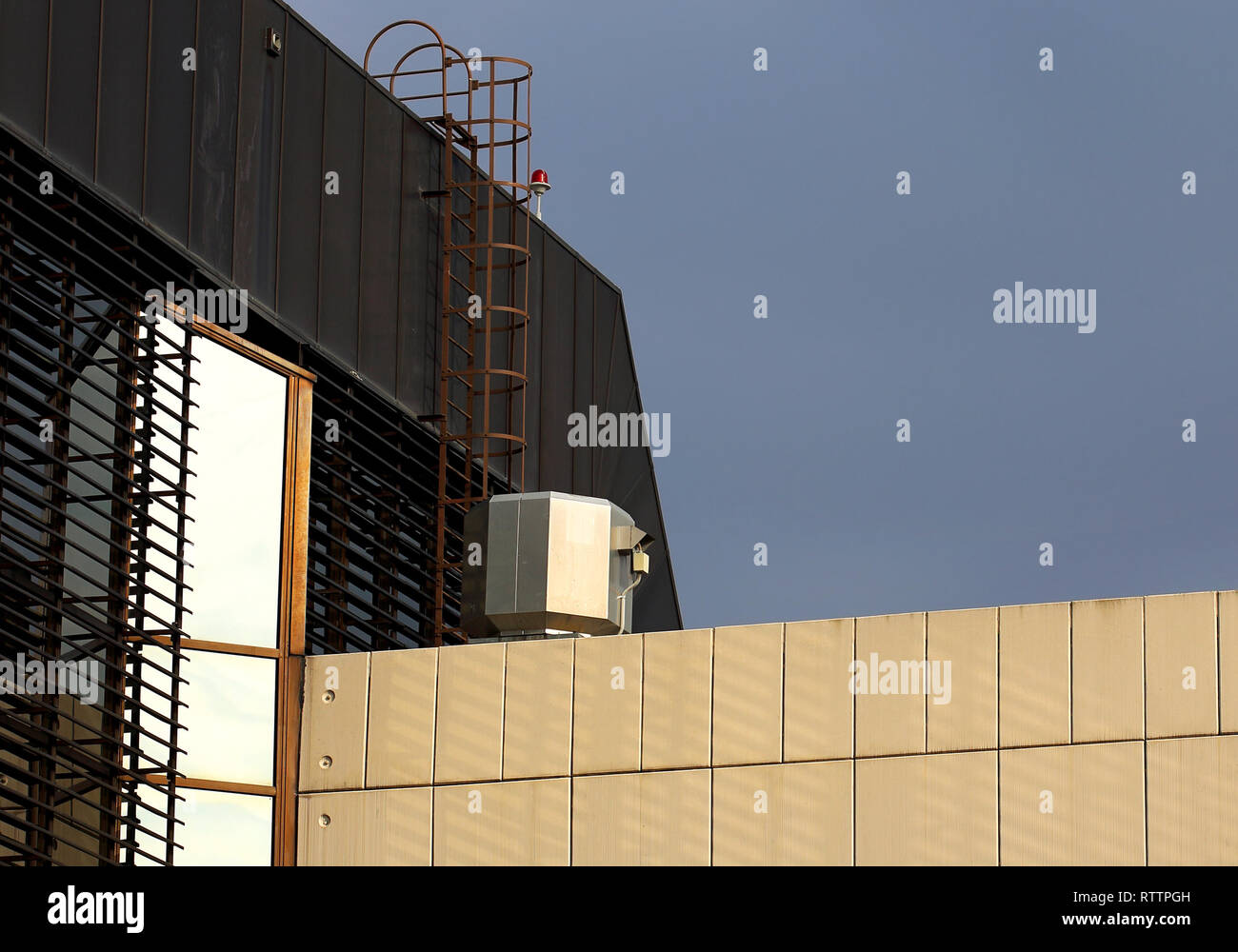 Ventilation and  metal staircase on the roof of an industrial building Stock Photo
