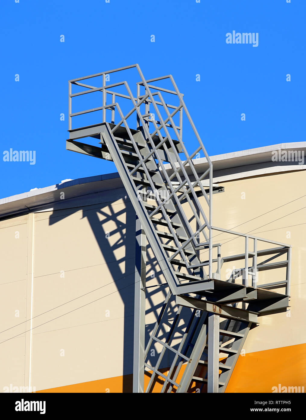 Ladder section of the multi-span metal staircase at the outside of the industrial building Stock Photo