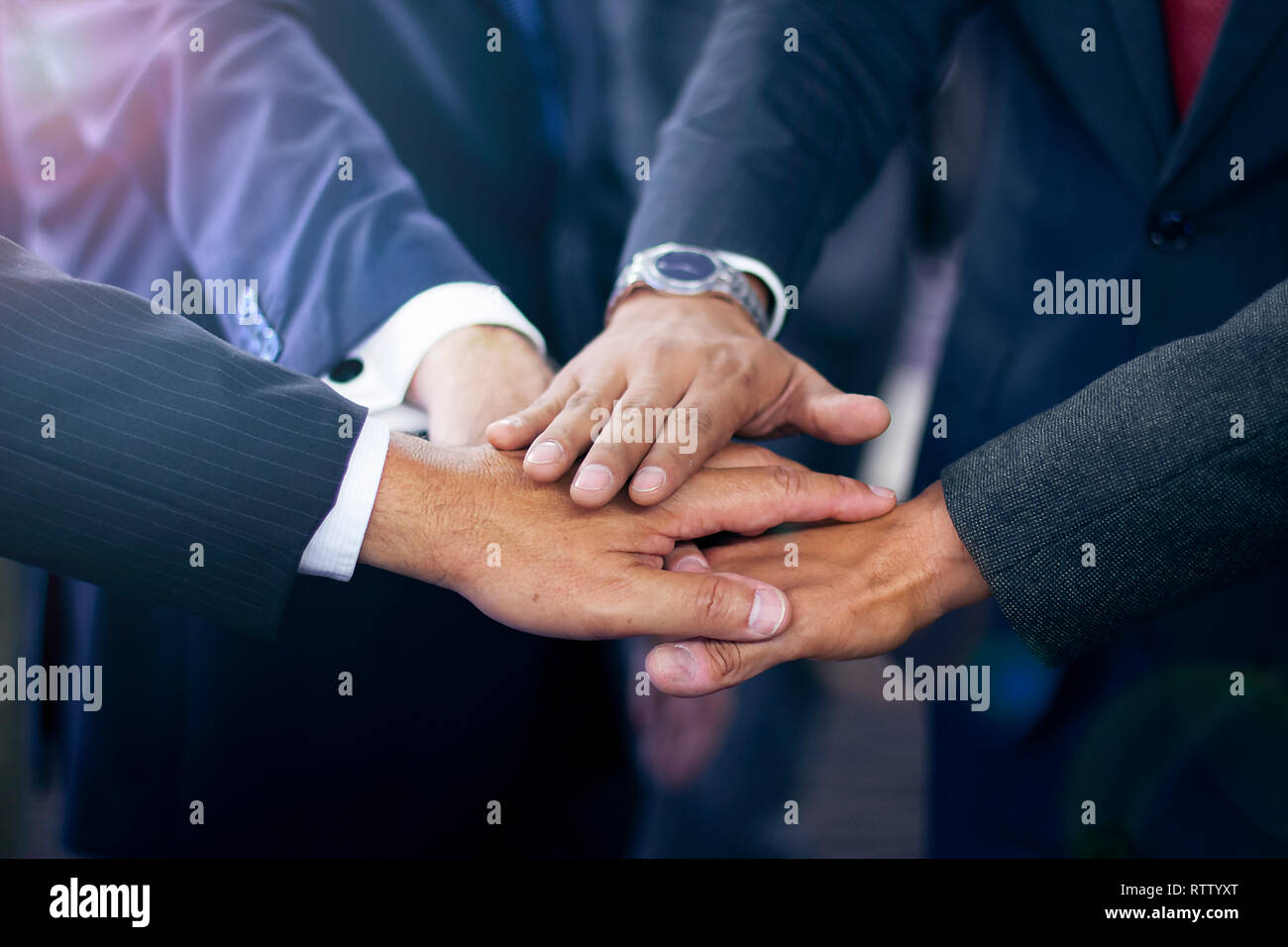 Group of hispanic business people joining hands wearing suits, teamwork and collaboration concept Stock Photo