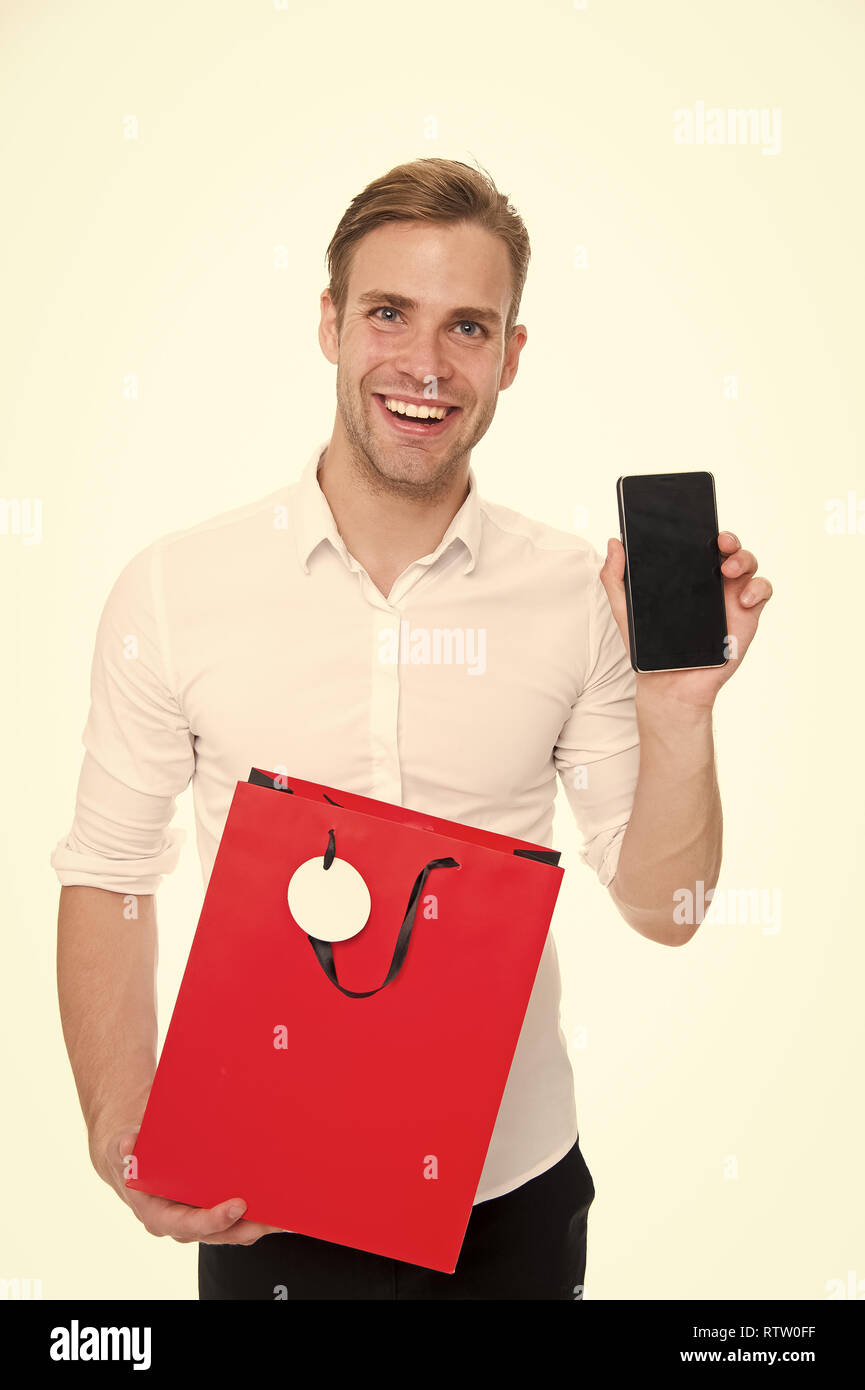 Hard earned cash and precious time you are spendings worth few minutes of preparation. Shopping online save time. Guy with smartphone and shopping bag happy purchase online. Shopping application. Stock Photo
