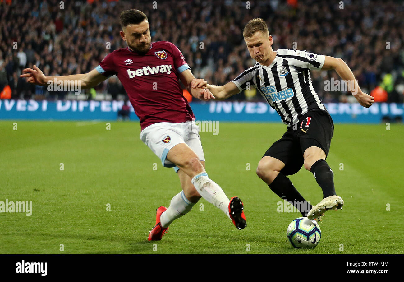 West Ham United's Robert Snodgrass (left) and Newcastle United's Matt Ritchie battle for the ball during the Premier League match at London Stadium. Stock Photo