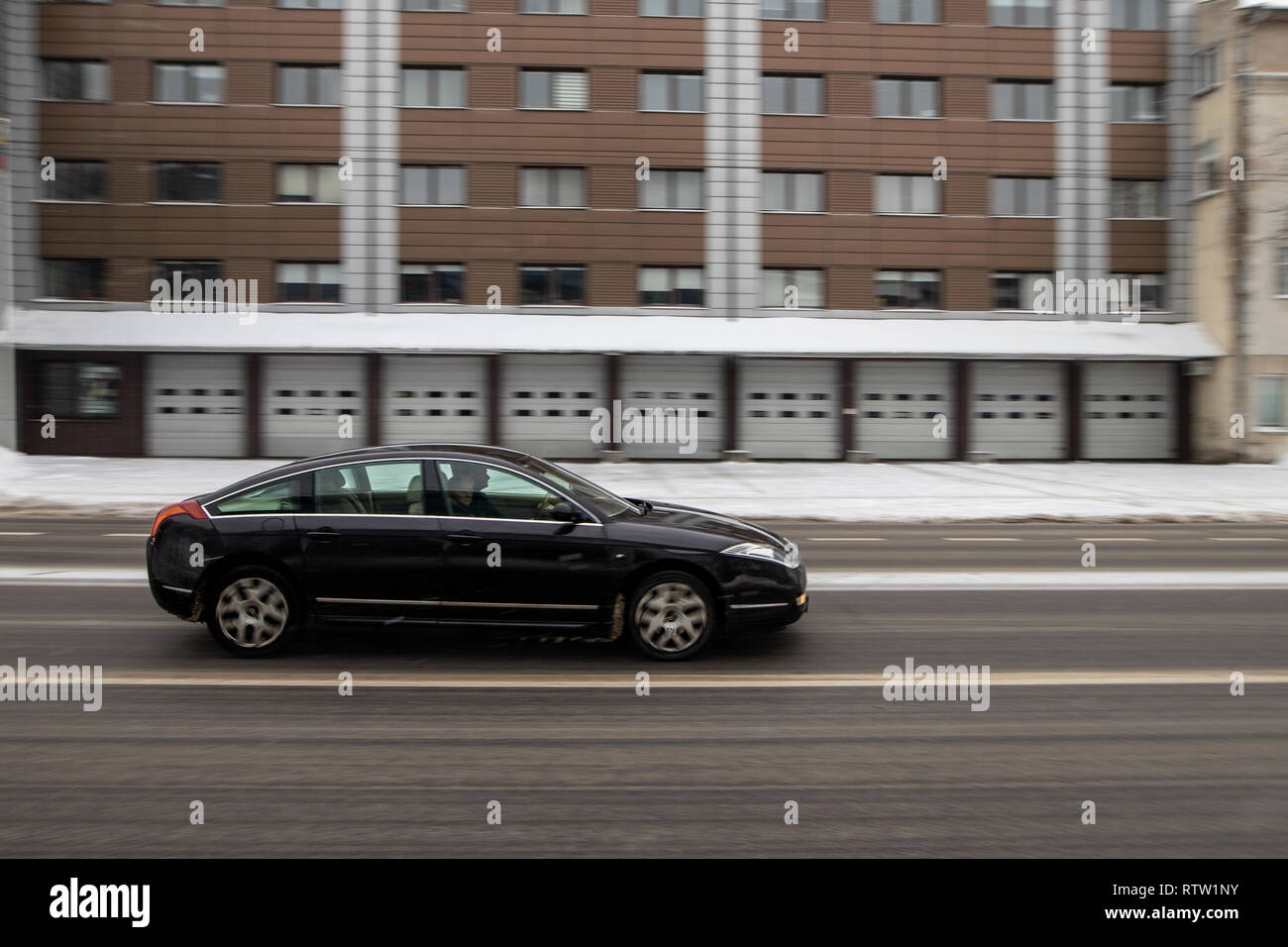 Black car is driving in city at day time Stock Photo Alamy