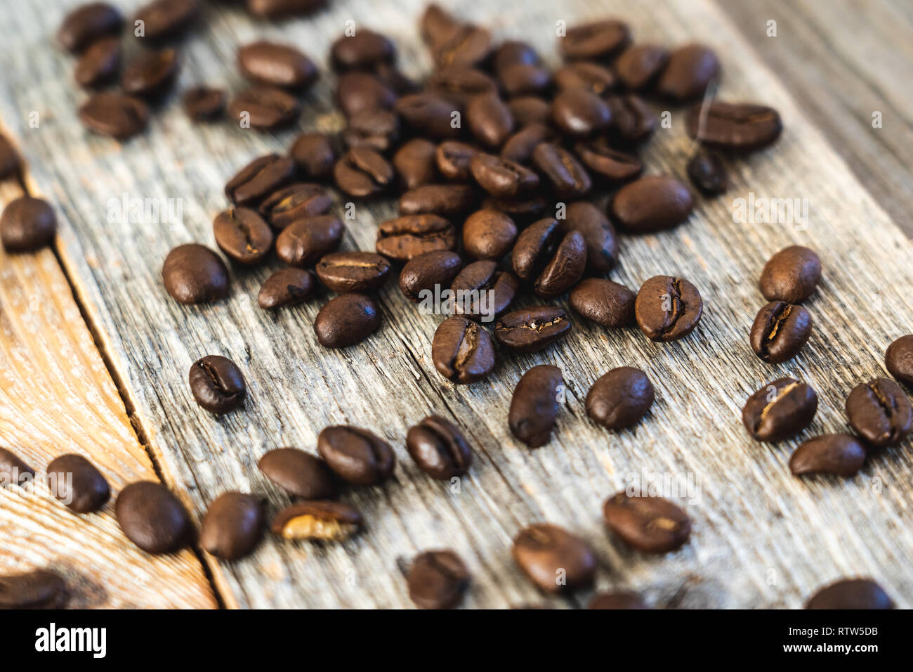 Close-up shot of roasted coffee beans on rustic wooden boards Stock Photo
