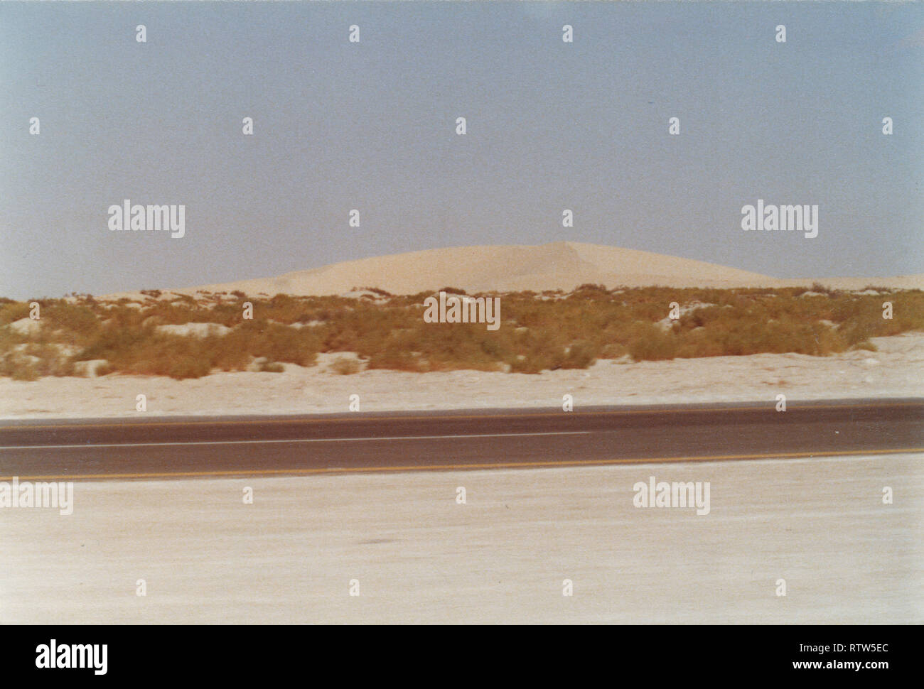 The road from the Abqaiq, a Saudi Aramco camp, to Qarrayah Beach, the town's closet private beach. The road is filled with sand dunes and often has camel herds driven by shepherds. Stock Photo