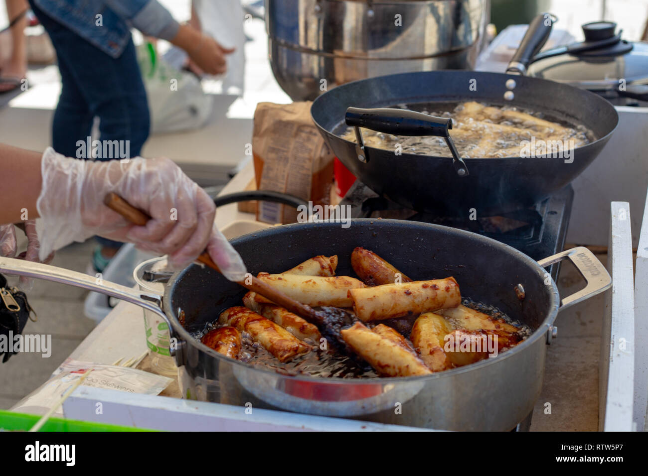 Sweet and savoury spring rolls being prepared for sale at a food market for Philippines Day in Christchurch Square, New Zealand Stock Photo