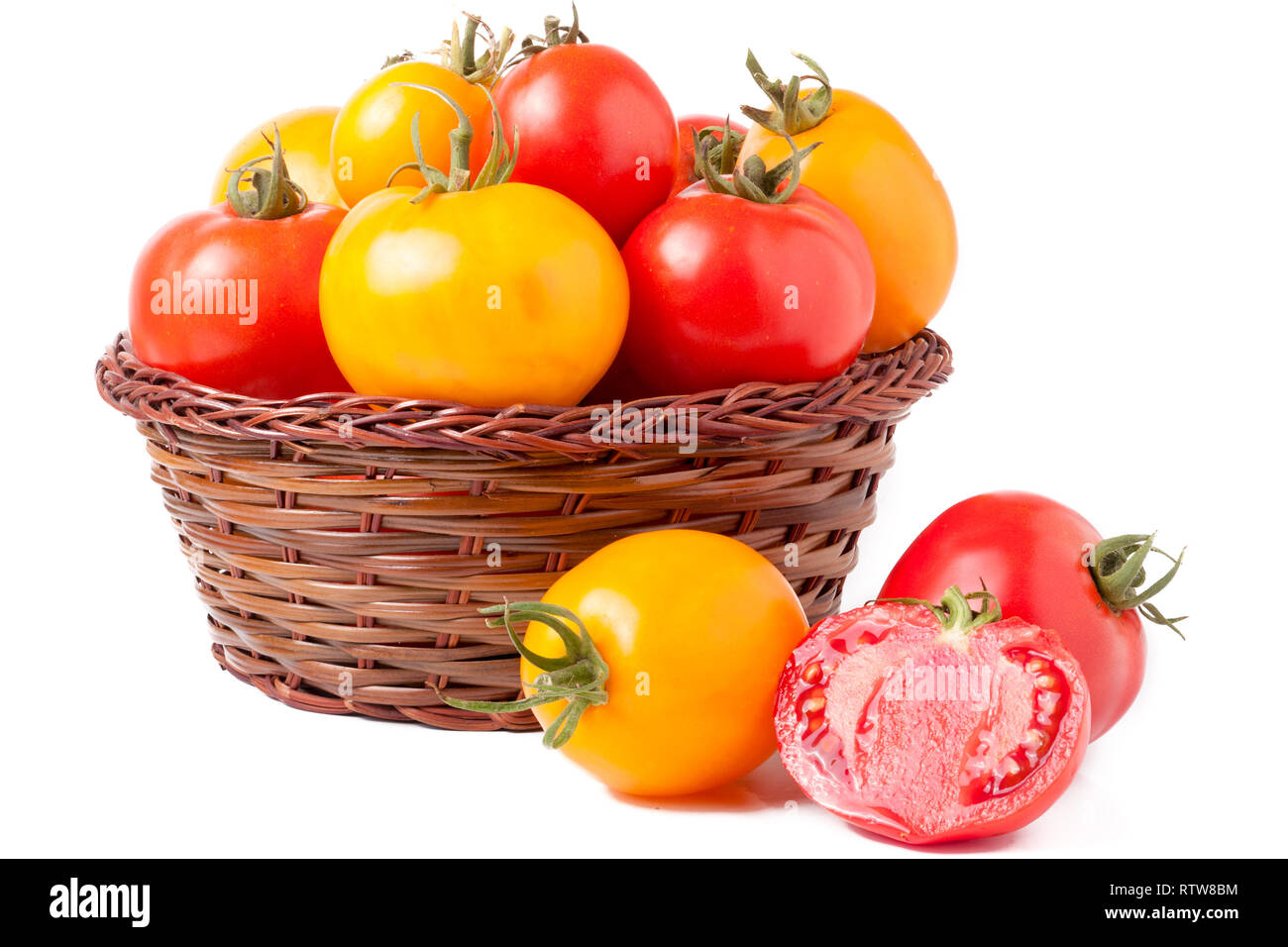 red and yellow tomatoes in a wicker basket isolated on white background ...