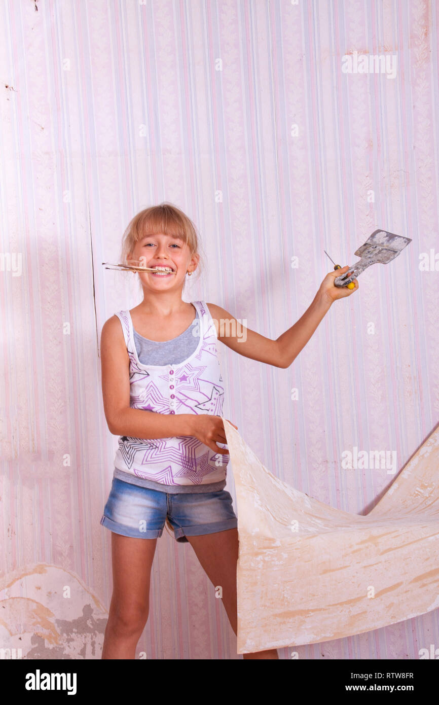 girl remove old wallpapers from wall Stock Photo Alamy