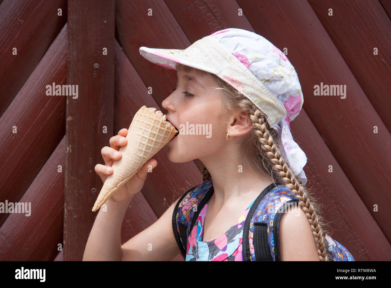 girl in a cap eats ice cream Stock Photo