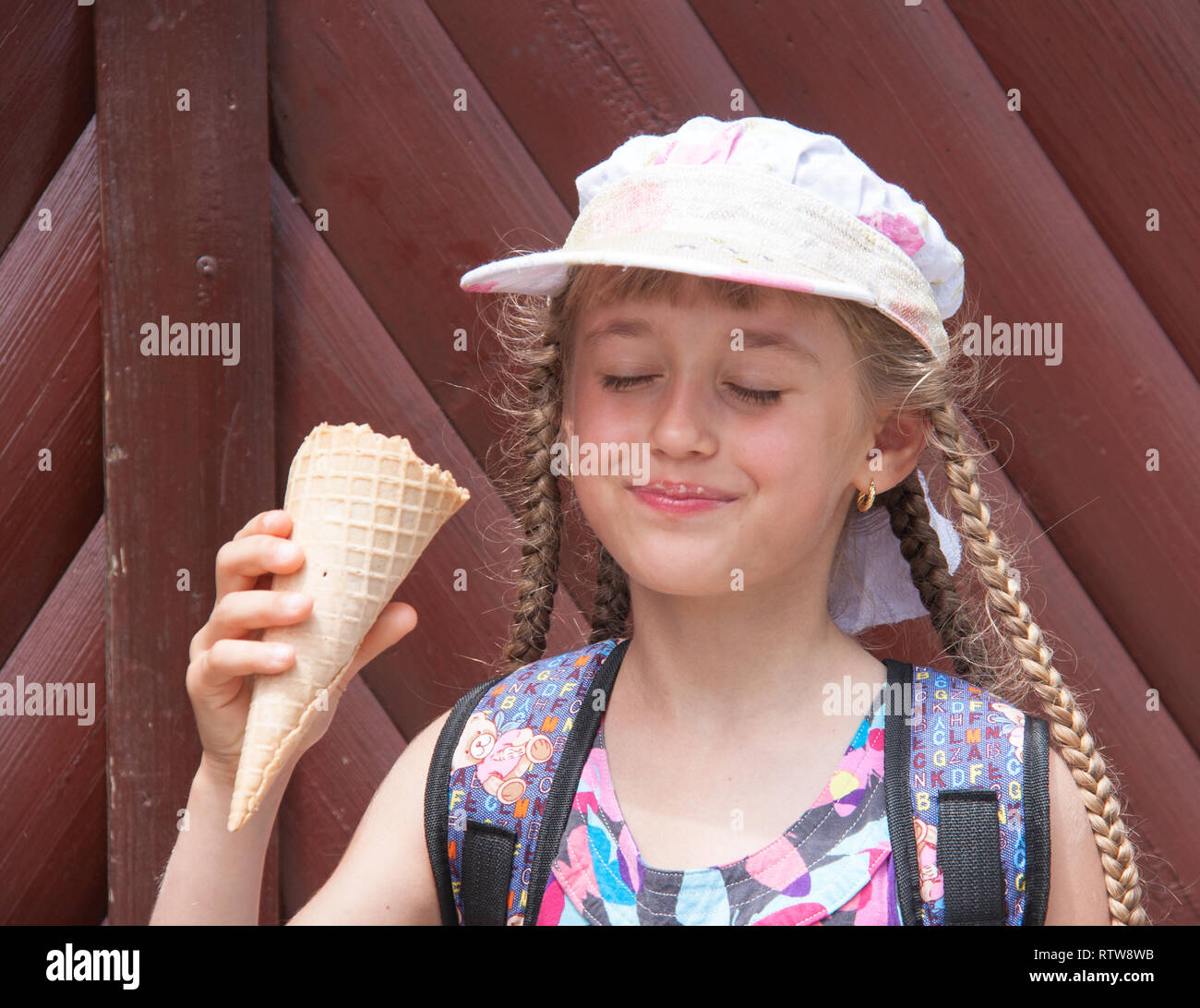 girl in a cap eats ice cream Stock Photo