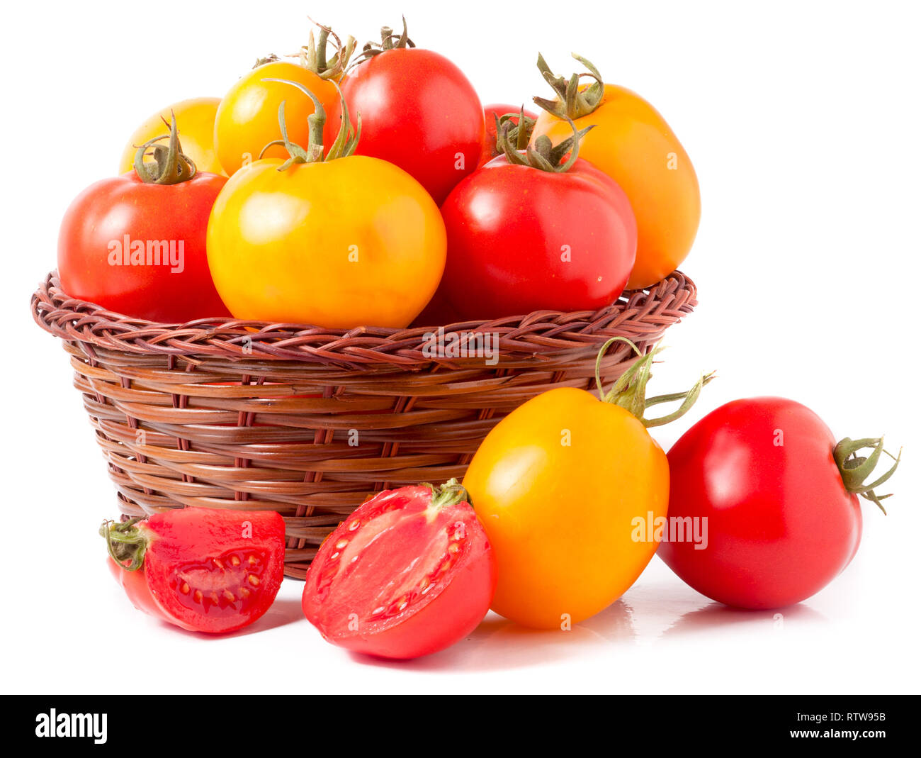 red and yellow tomatoes in a wicker basket isolated on white background ...
