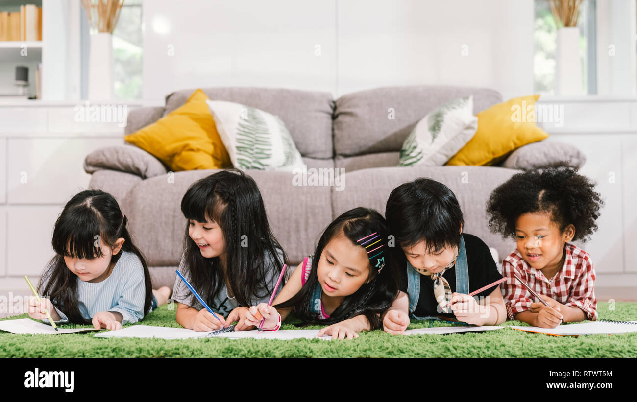 Group of five multi-ethnic young cute preschool kids, boy and girls happy studying or drawing together at home or school. Children education concept Stock Photo