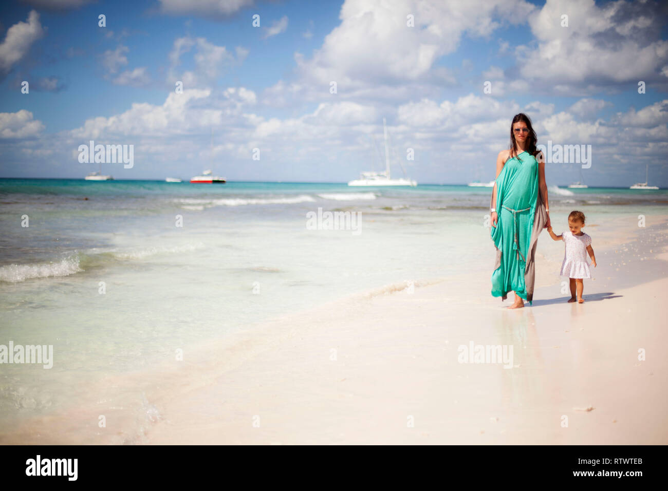 Mother and beby girl walking on tropical beach Stock Photo